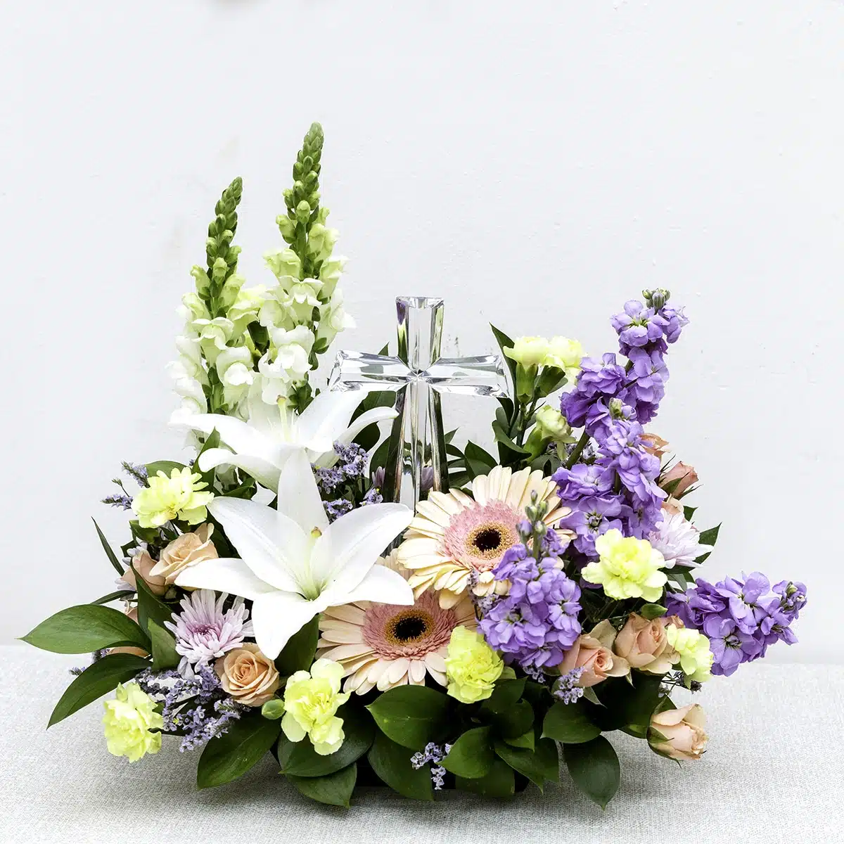 Sympathy arrangement with crystal cross delivered to a San Diego funeral home by Four Seasons Flowers